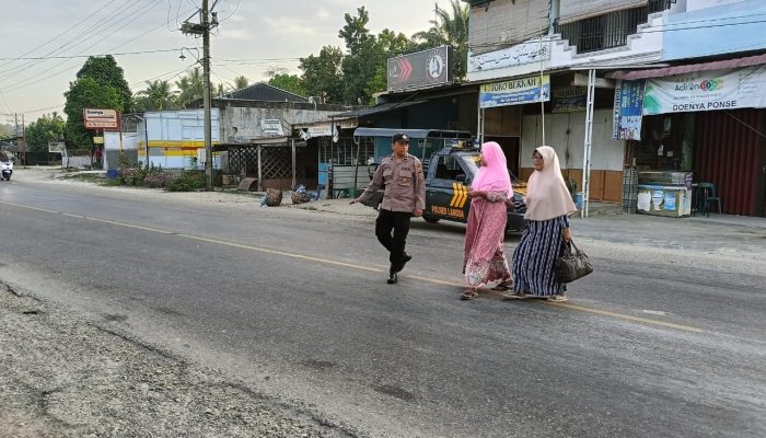 Personil Polsek Rantau Selamat Sebrangkan Warga dan Anak Sekolah