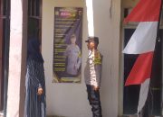Tingkatkan Keterlibatan Keluarga, Bhabinkamtibmas Ajak Warga Lewat Spanduk untuk Pemilukada Aman dan Damai