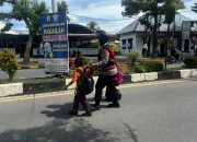 Polwan Bantu Anak Sekolah Menyeberang Jalan di Langsa